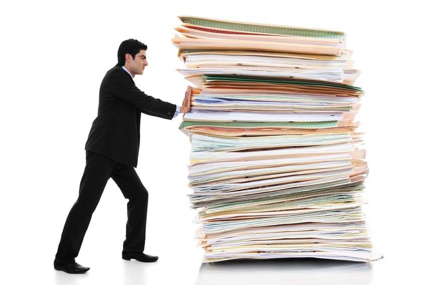 man pushing a giant stack of papers